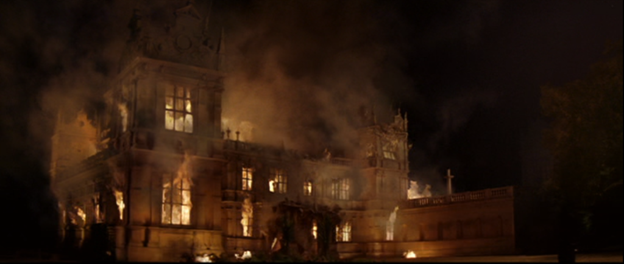 Scene from Warner Bros. Batman Begins: Wayne manor burns down after Ra’s attack